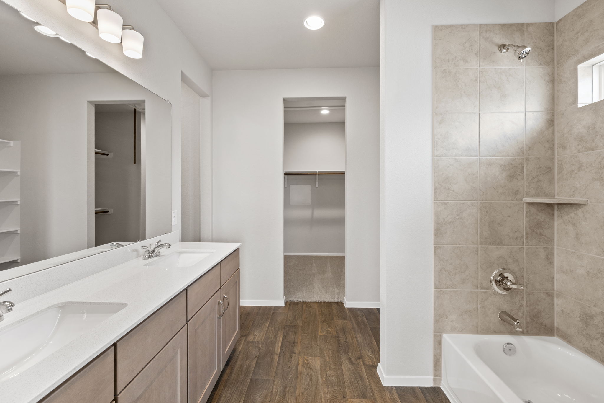 2460 Winding Creek Road Kyle, TX 78640 - Photo 11 of 20 A well-appointed bathroom features a double vanity and sleek modern finishes, with convenient closet access.