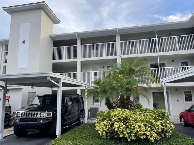 a view of a house with a yard and potted plants