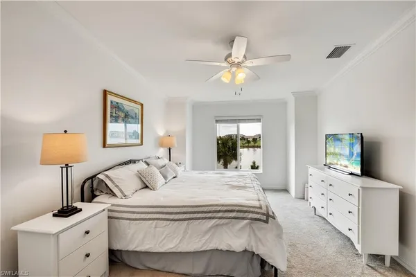 a bedroom with a bed and a flat tv screen on dresser