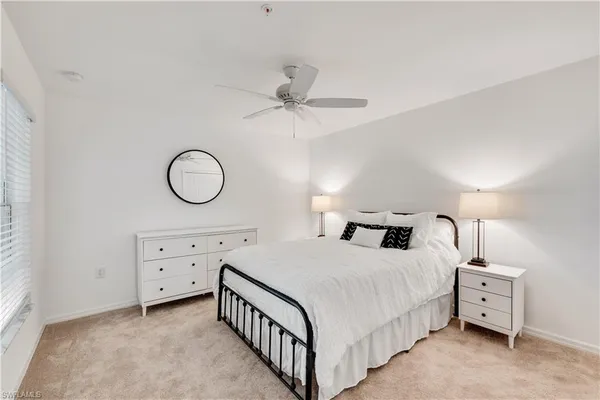 a bedroom with a bed a chandelier and a dresser