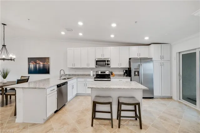 a kitchen with a cabinets a sink a counter and stainless steel appliances