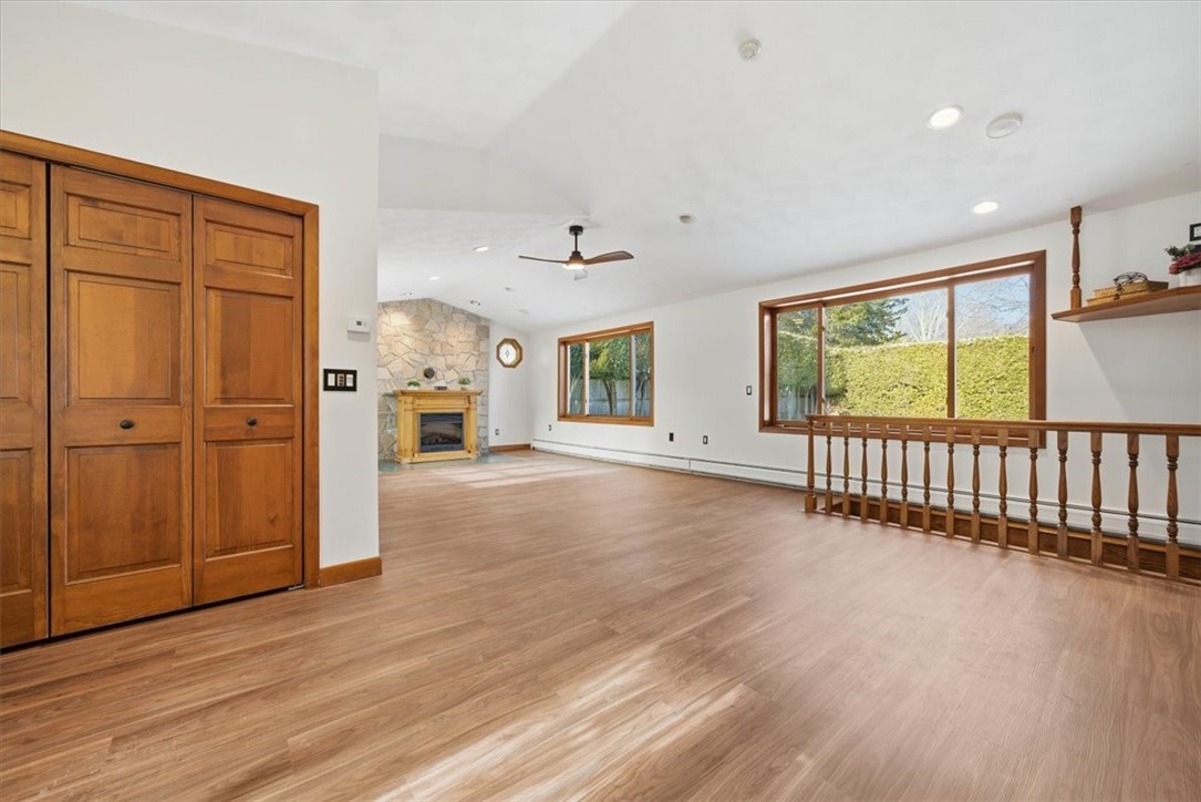 8 Meadow Lane Coventry, RI 02816 - Photo 5 of 45 . The tiled entry opens to a show-stopping Great Room with vaulted ceilings, brand-new luxury vinyl plank flooring, stone hearth centerpiece, stained-glass details, and oversized windows.