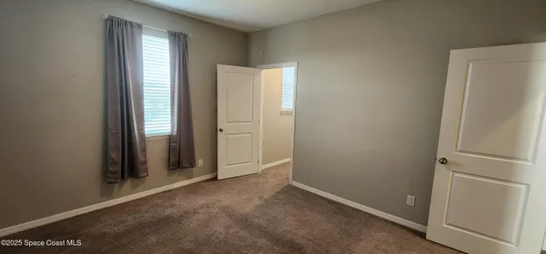 an empty room with windows and closet