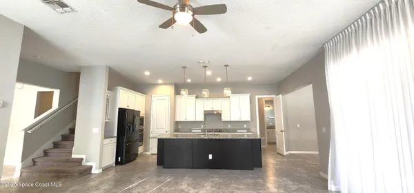 a view of a kitchen with a sink and a refrigerator