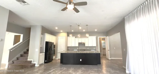 a view of a kitchen with a sink and a refrigerator