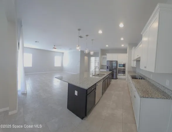 a large kitchen with stainless steel appliances granite countertop a large counter top and a stove