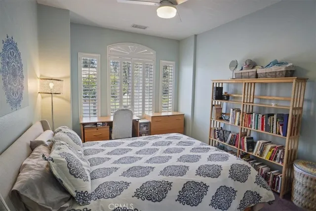 a bedroom with a large bed and a book shelf