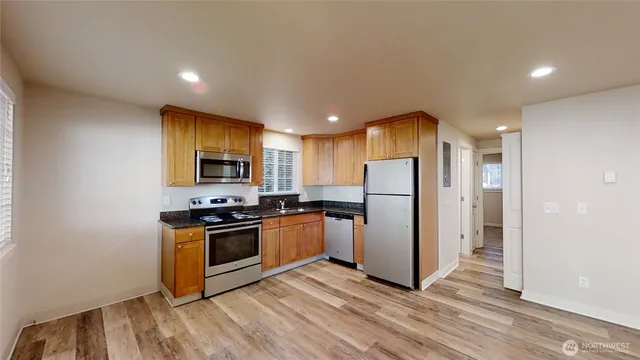 a kitchen with stainless steel appliances granite countertop a refrigerator a stove top oven a sink and dishwasher