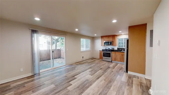 a view of kitchen with refrigerator stove and wooden floor