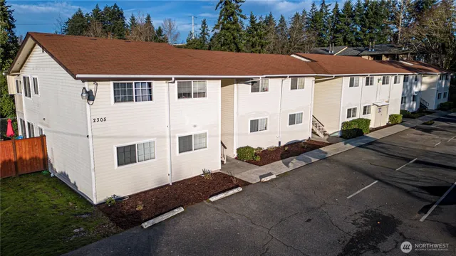 a white house covered with tall trees