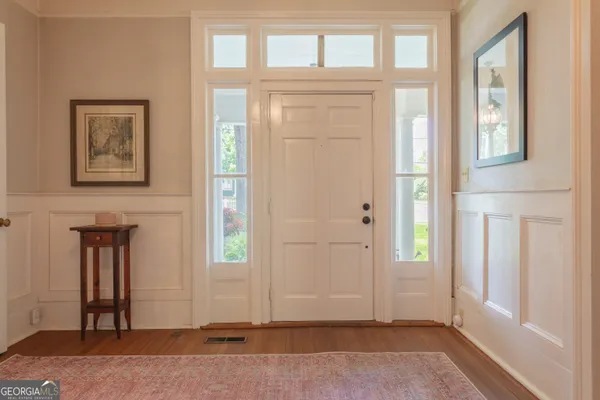 a living room with a chairs and a floor to ceiling window