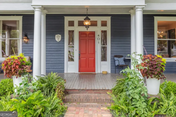 a front view of a house with lots of potted plants