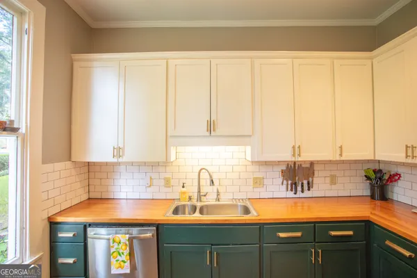 a kitchen with kitchen island granite countertop a sink cabinets and stainless steel appliances