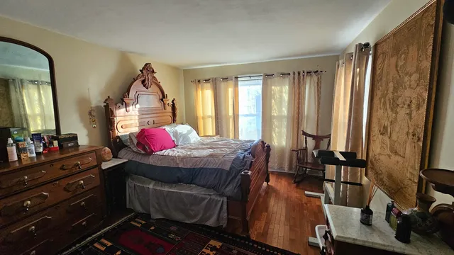 a bedroom with a bed window and dresser