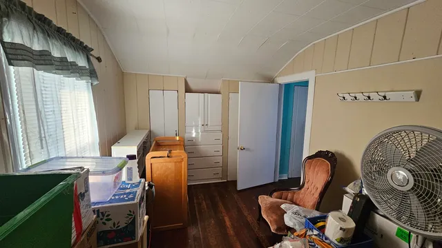 a view of a workspace with furniture and a window