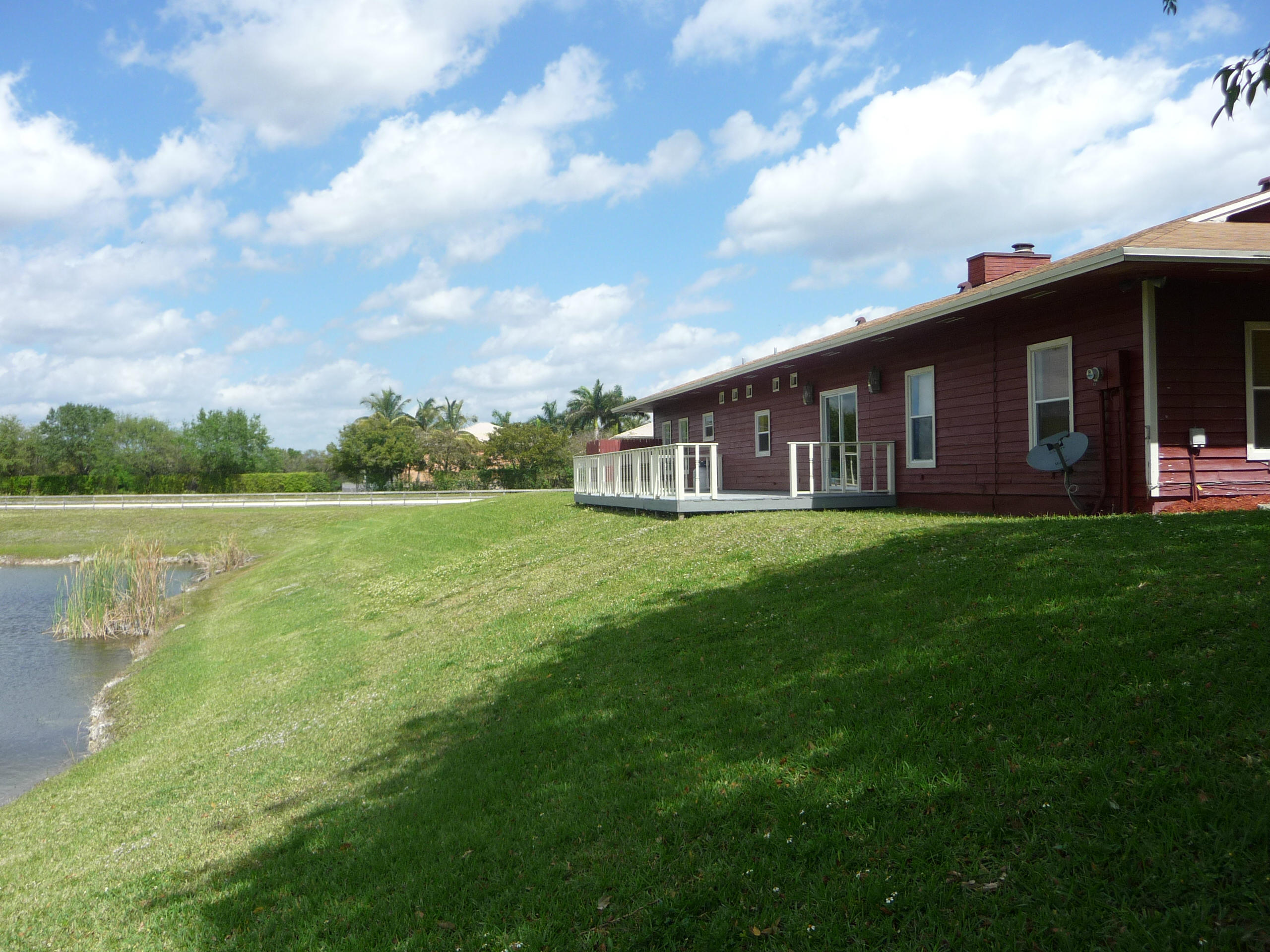 19655 118th Trail South, Unit FRNT Boca Raton, FL 33498 - Photo 17 of 31 a view of a house with a big yard and large trees