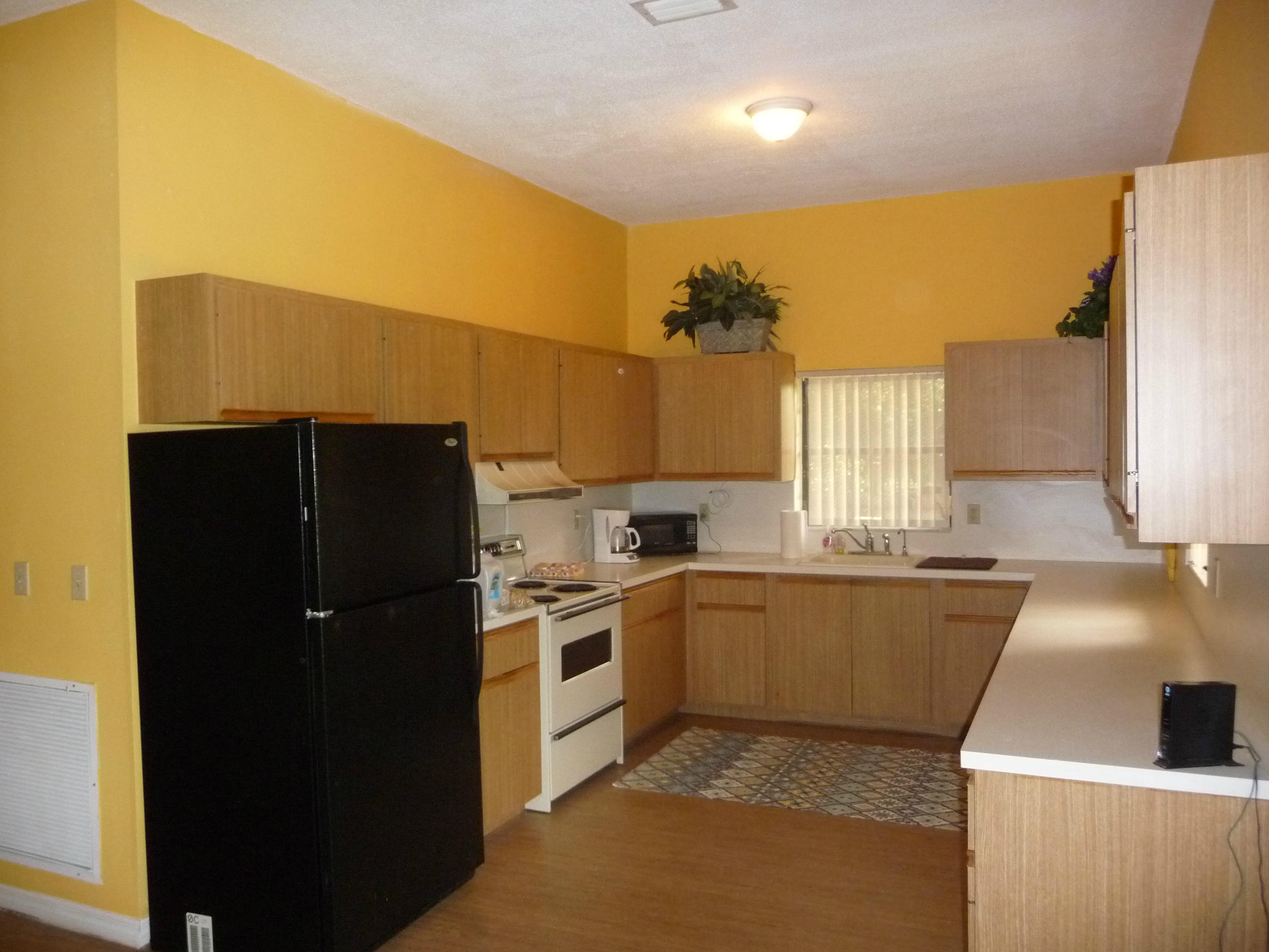 19655 118th Trail South, Unit FRNT Boca Raton, FL 33498 - Photo 23 of 31 a kitchen with granite countertop a refrigerator a sink a stove and cabinets