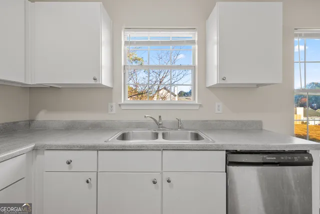 a kitchen with a sink cabinets and window