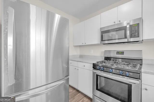a kitchen with stainless steel appliances white cabinets and a stove