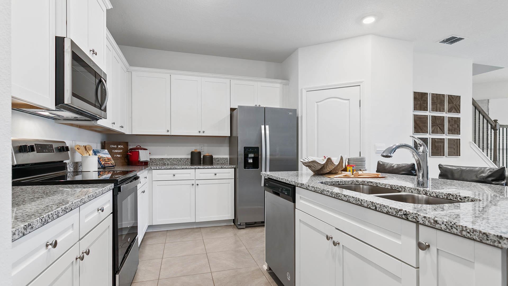 512 Redbud Road Palm Coast, FL 32137 - Photo 7 of 33 a kitchen with stainless steel appliances granite countertop a sink stove and refrigerator