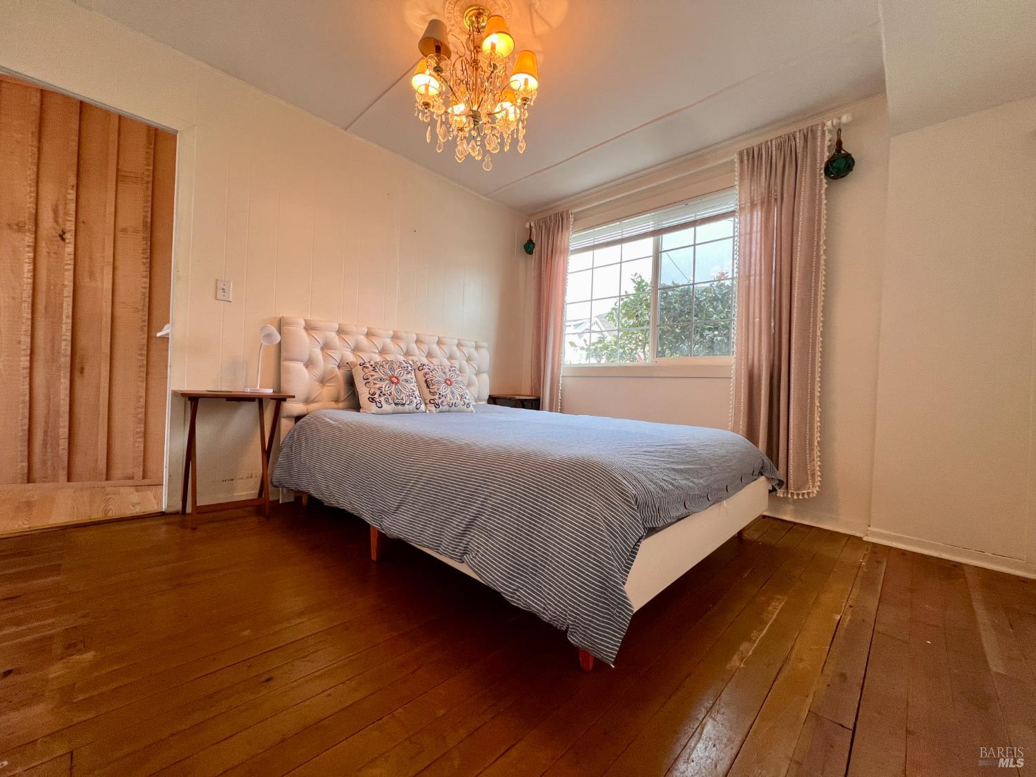 75 Ocean View Avenue Dillon Beach, CA 94929 - Photo 13 of 30 a bedroom with a large bed and a chandelier