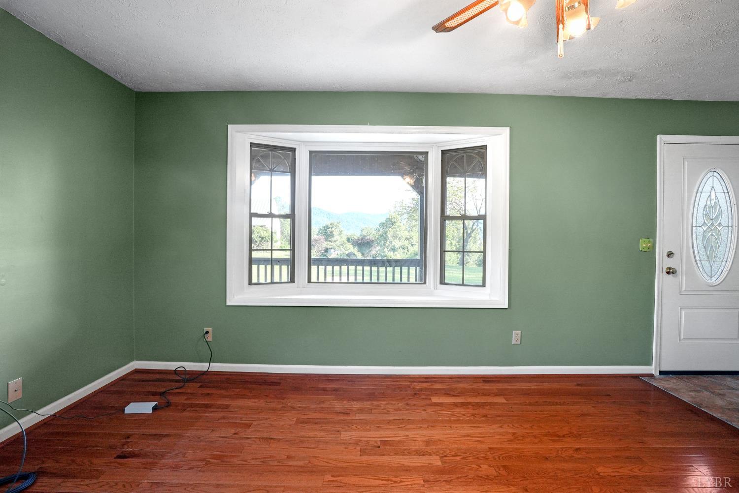 2294 High Peak Road Monroe, VA 24574 - Photo 11 of 53 an empty room with wooden floor and windows