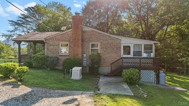 a view of a house with backyard and trees