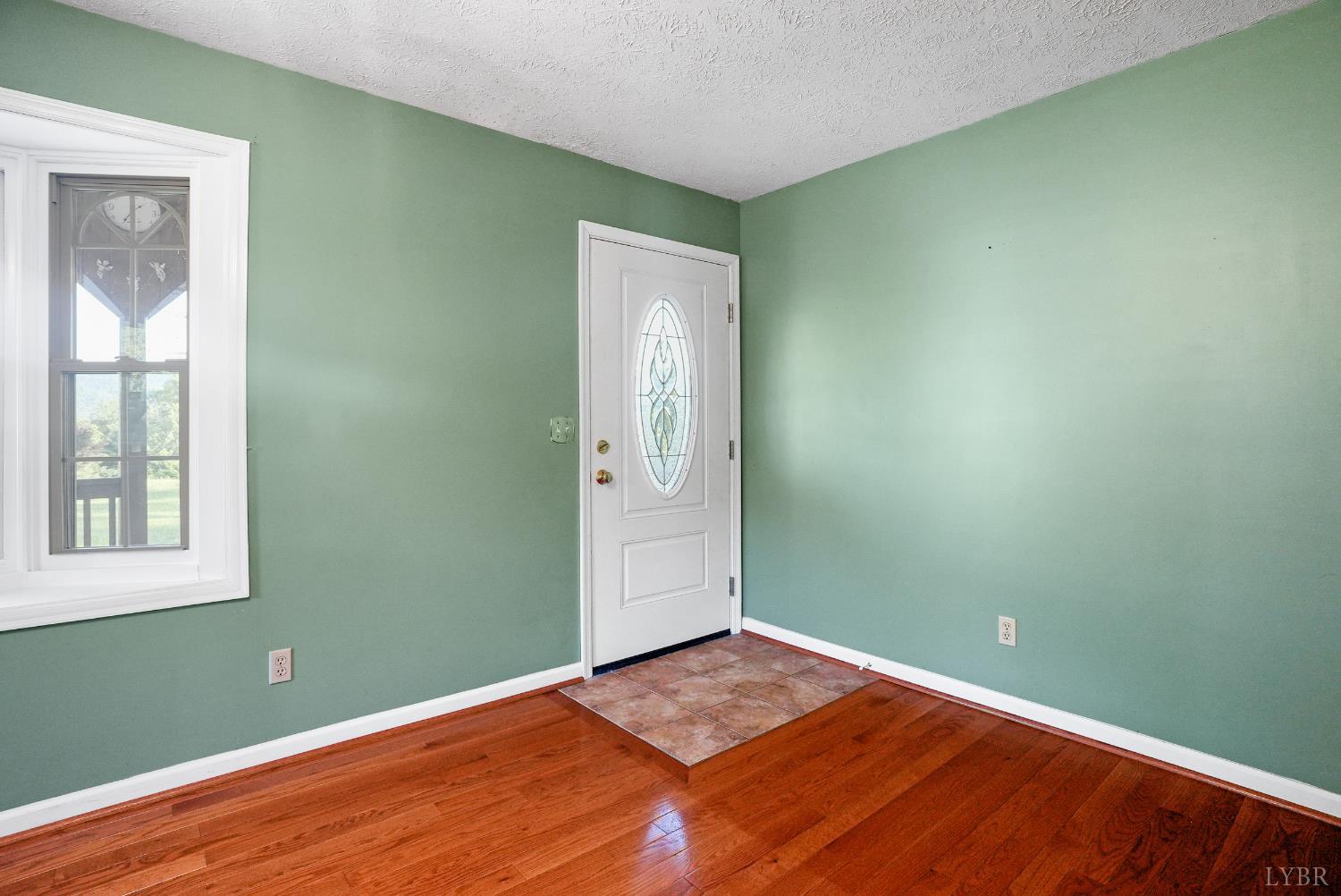 2294 High Peak Road Monroe, VA 24574 - Photo 9 of 53 an empty room with wooden floor and windows