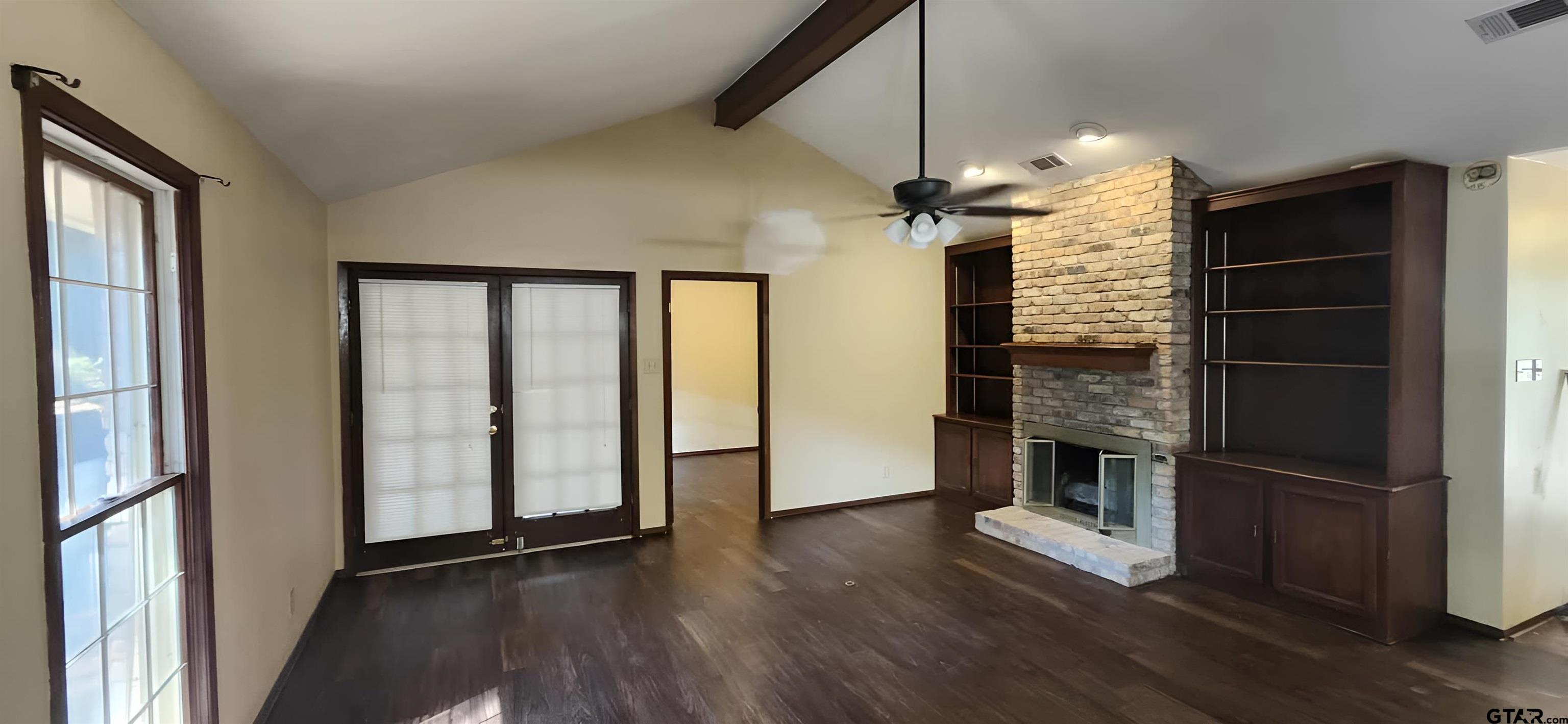 14141 County Road 1237 Tyler, TX 75703 - Photo 3 of 15 an empty room with wooden floor fireplace and windows