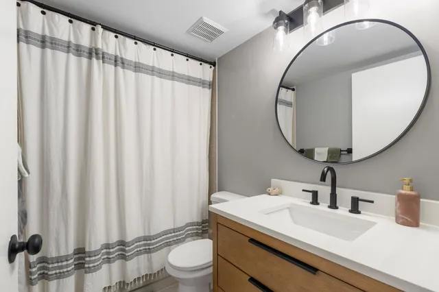 a bathroom with a sink a toilet and a mirror