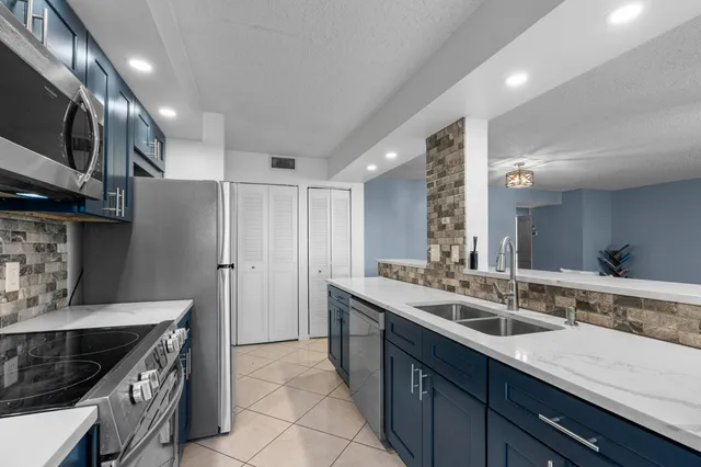 a kitchen with stainless steel appliances granite countertop a sink and a stove
