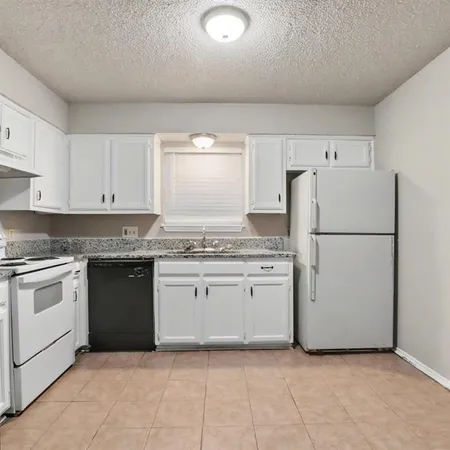 a kitchen with granite countertop cabinets and white appliances