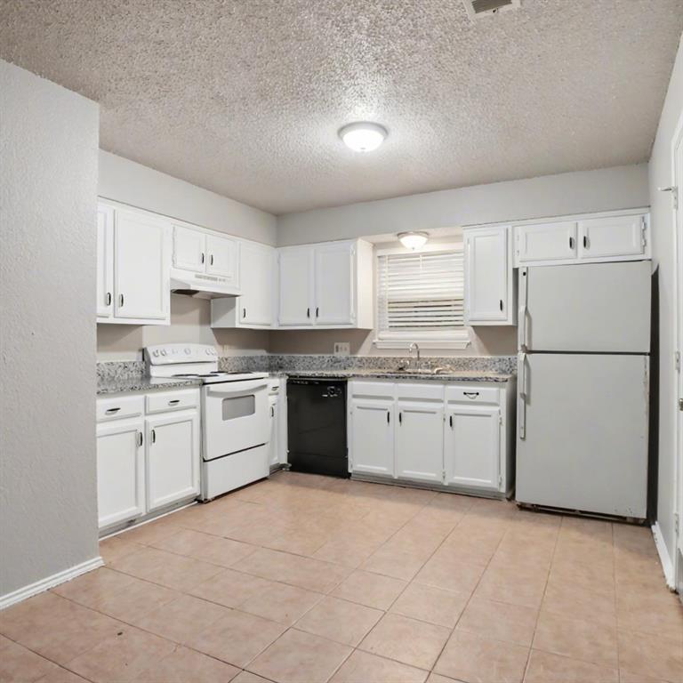 2511 West Prairie Street Denton, TX 76201 - Photo 3 of 10 a kitchen with a white stove refrigerator and white cabinets