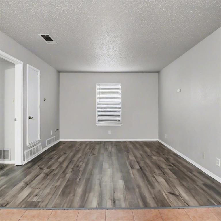 2511 West Prairie Street Denton, TX 76201 - Photo 5 of 10 an empty room with wooden floor and windows