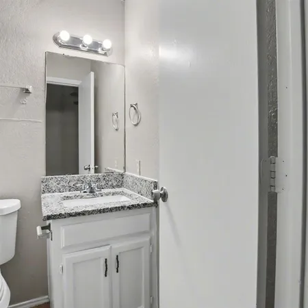 a bathroom with a granite countertop sink and a mirror