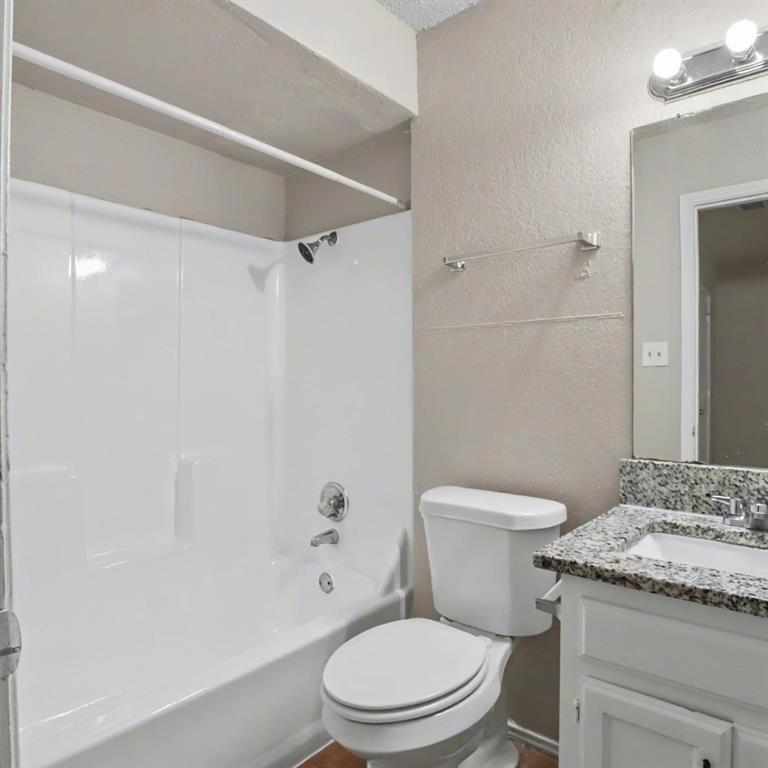 2511 West Prairie Street Denton, TX 76201 - Photo 8 of 10 a white toilet and a shower curtain