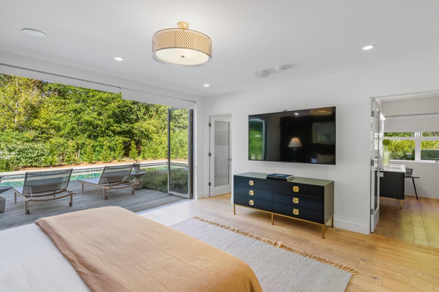 135 Willowbrook Drive Portola Valley, CA 94028 - Photo 25 of 50 a bedroom with furniture a flat screen tv and a fireplace