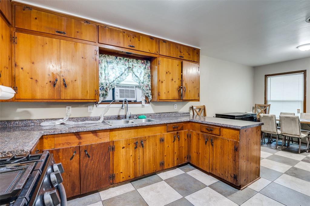 1447 Gillette Street Dallas, TX 75217 - Photo 4 of 12 a kitchen with a sink a counter top space and cabinets