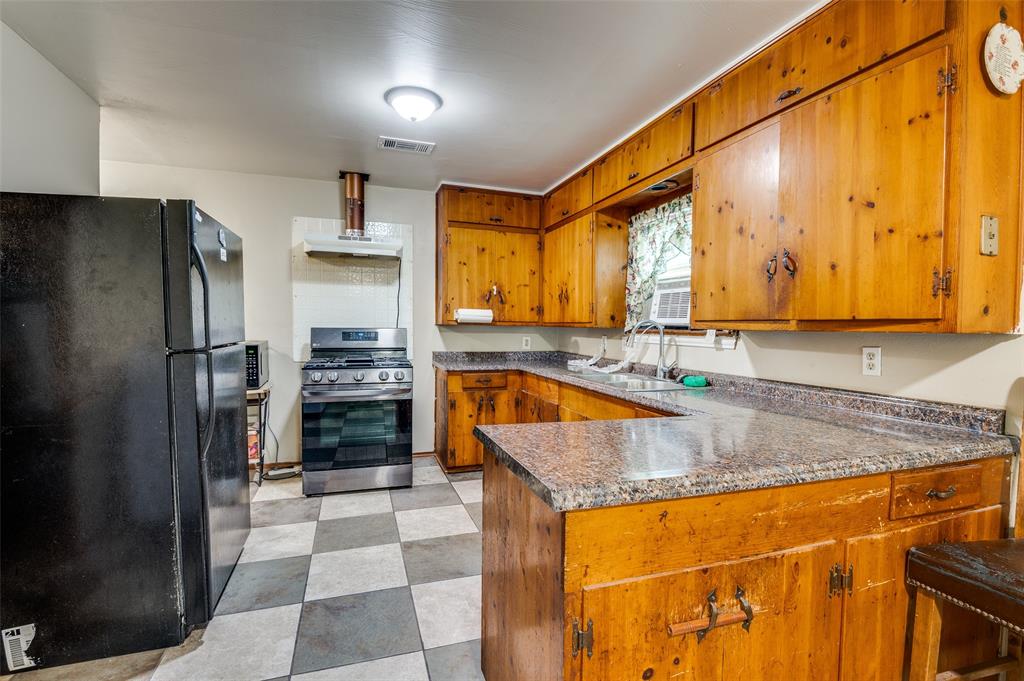 1447 Gillette Street Dallas, TX 75217 - Photo 6 of 12 a kitchen with stainless steel appliances granite countertop a sink stove and refrigerator