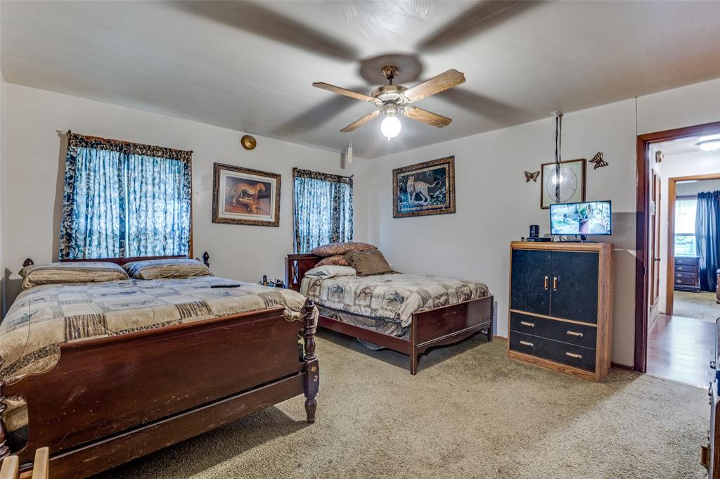 1447 Gillette Street Dallas, TX 75217 - Photo 7 of 12 a bedroom with a bed and a chandelier