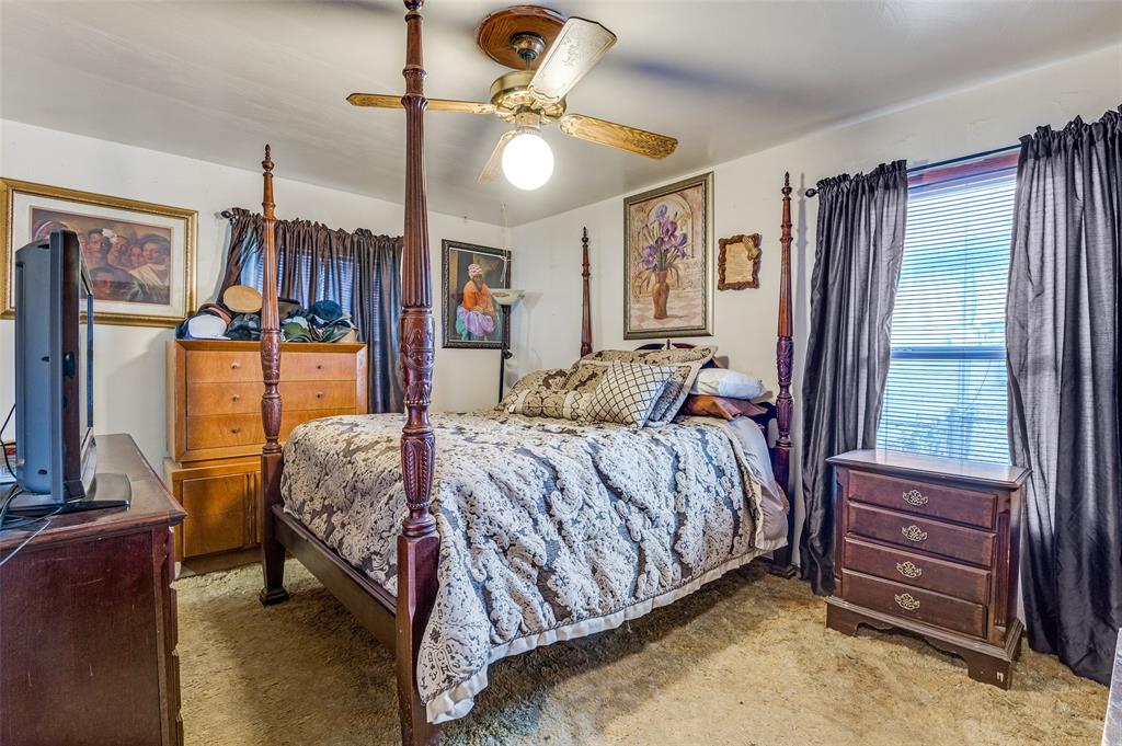 1447 Gillette Street Dallas, TX 75217 - Photo 9 of 12 a bedroom with a bed dresser and a flat tv screen