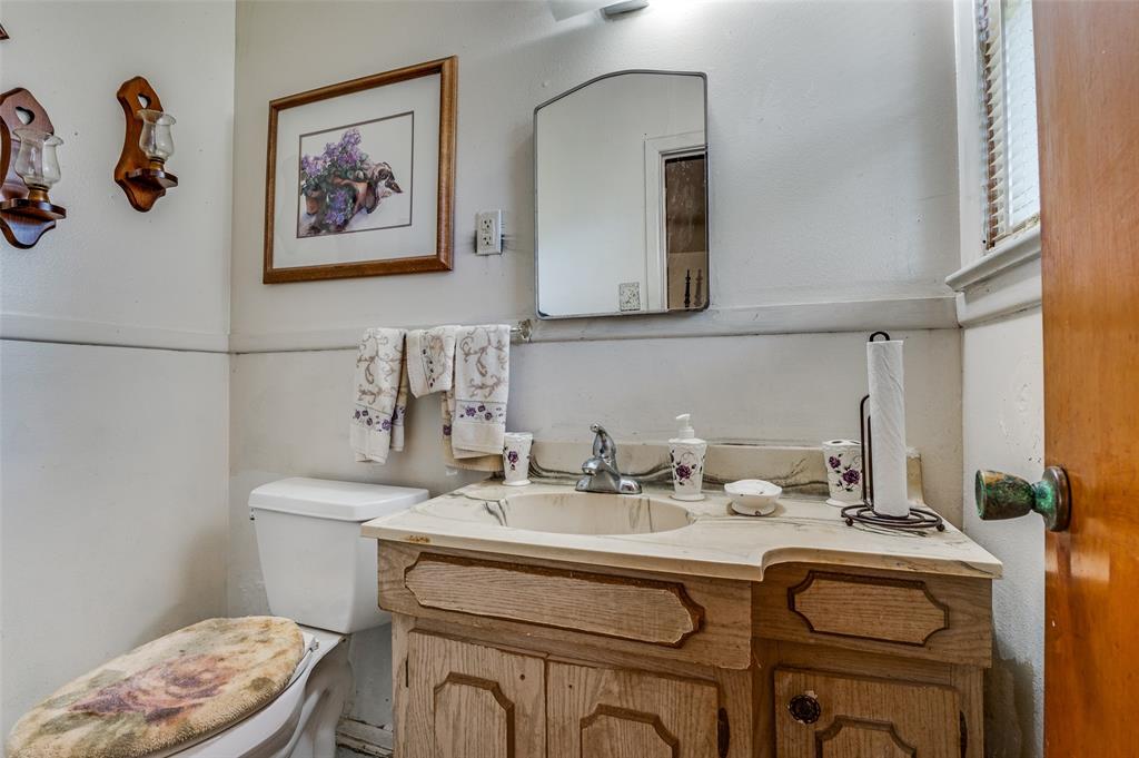 1447 Gillette Street Dallas, TX 75217 - Photo 10 of 12 a bathroom with a sink a toilet and a mirror