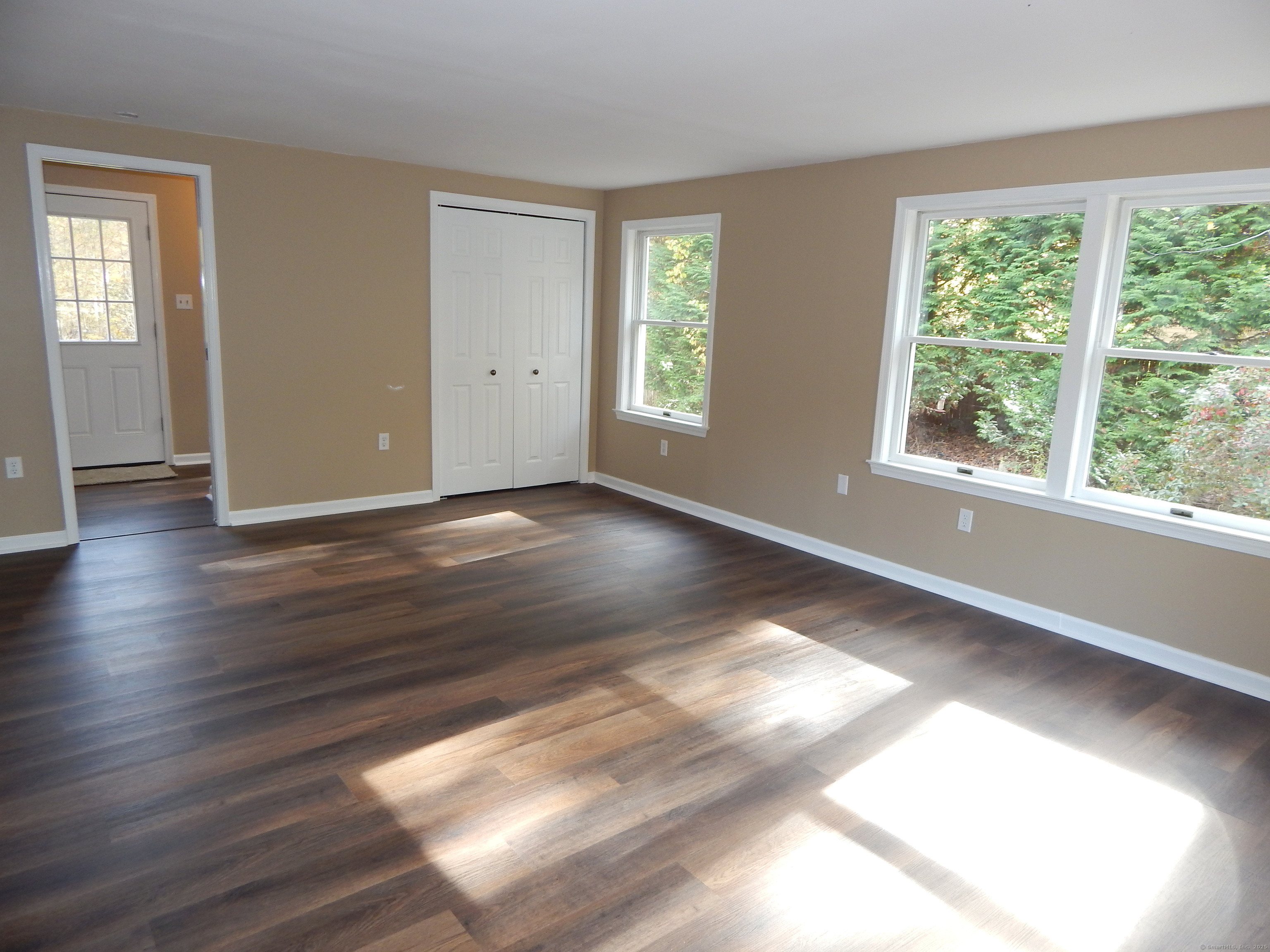 62 Bascom Road Lebanon, CT 06249 - Photo 14 of 34 a view of an empty room with wooden floor and windows