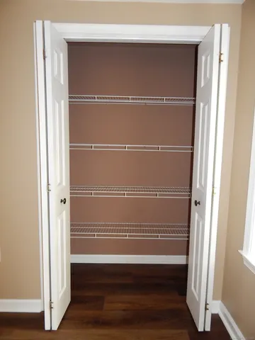 a view of walk in closet with empty racks