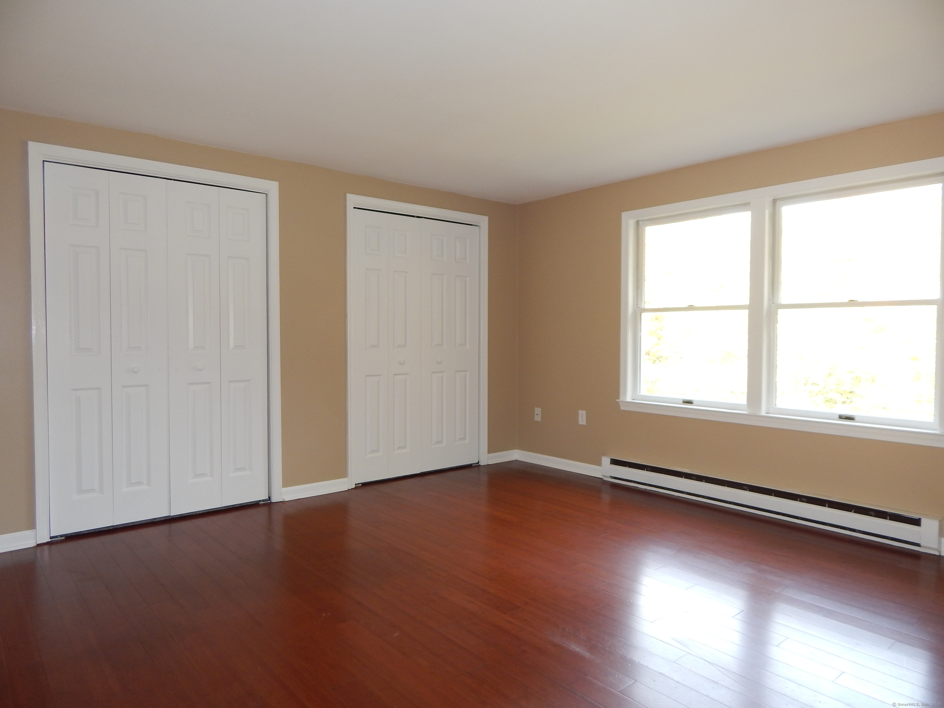 62 Bascom Road Lebanon, CT 06249 - Photo 21 of 34 a view of an empty room with wooden floor and a window