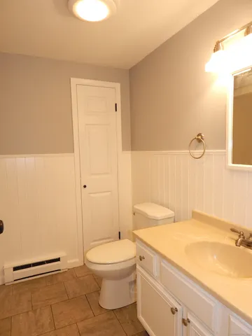 a bathroom with a granite countertop sink a toilet and shower
