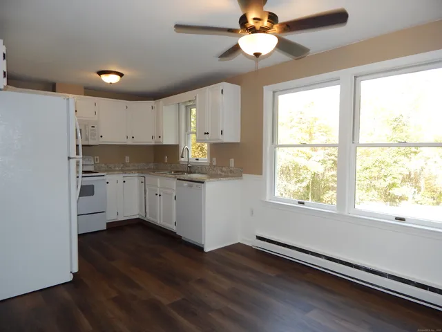 a kitchen with wooden floors and white cabinets