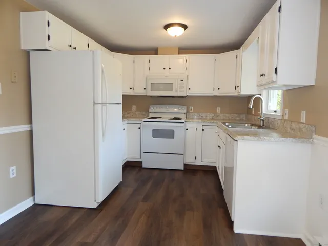 a kitchen with a white cabinets stove and refrigerator