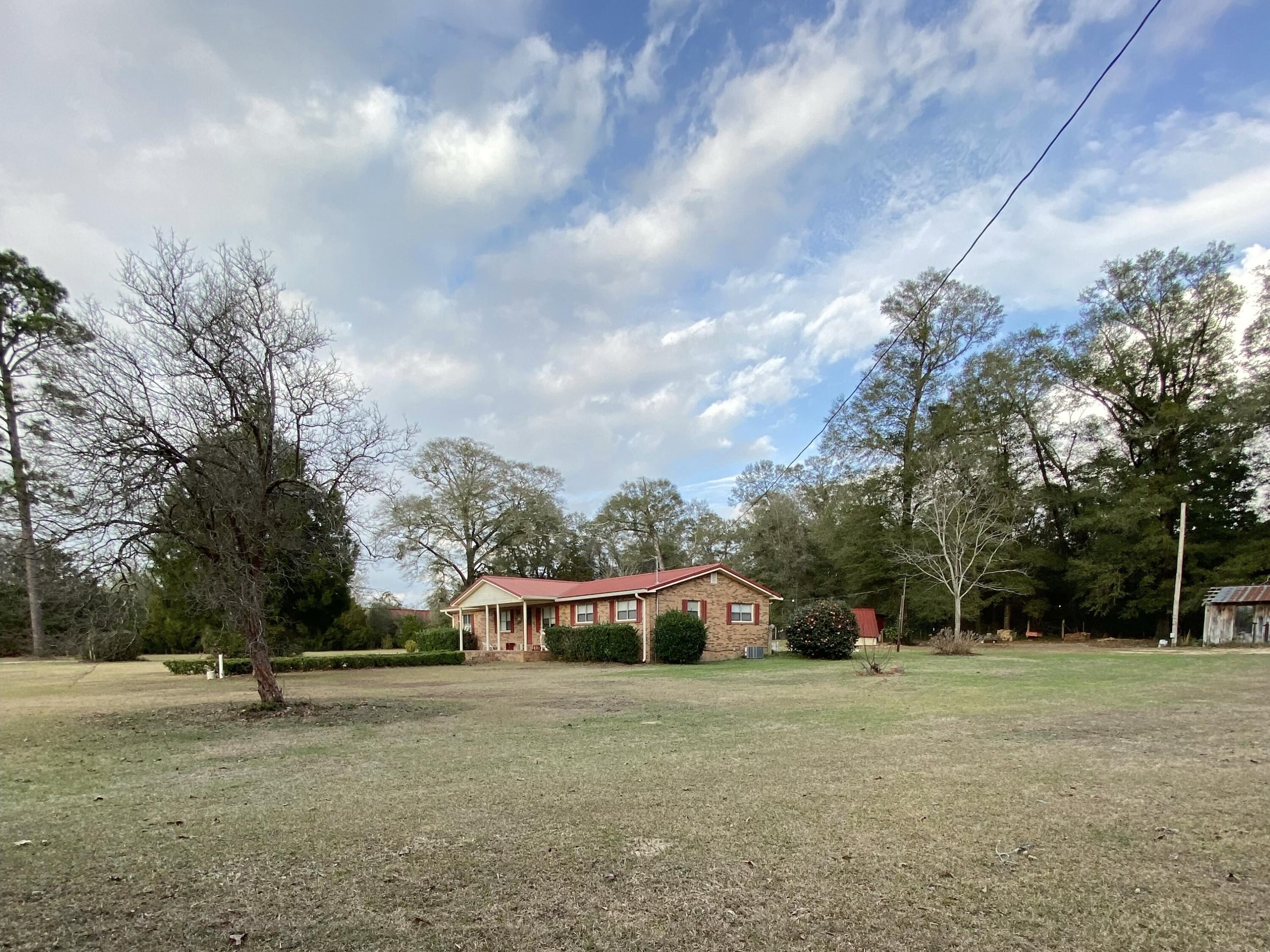 186 McLaughlin Road Milton, FL 32570 - Photo 4 of 26 a front view of a house with a yard and trees