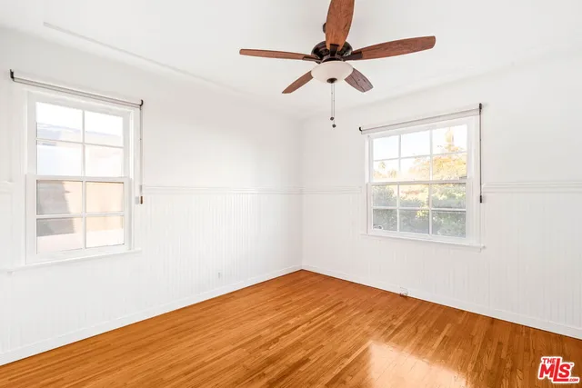 an empty room with a window and wooden floor